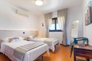 sypialnia z 2 łóżkami, stołem i biurkiem w obiekcie LAS CALAS Nice apartment near the sea. w mieście Portopetro +31 zdjęć