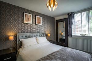 - une chambre avec un grand lit et un lustre dans l'établissement Stunning 1BD Flat close to Manchester City Centre, à Manchester