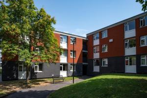 an apartment building with a tree and a park at Stunning 1BD Flat close to Manchester City Centre in Manchester