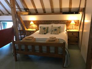 a bedroom with a large bed with two night stands at The Stables at Henham Park in Southwold