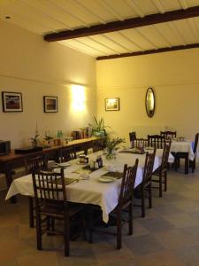 uma sala de jantar com uma mesa e cadeiras, uma mesa e uma espreguiçadeira em The Stables at Henham Park em Southwold