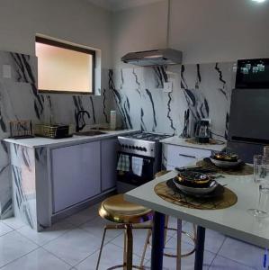a kitchen with a stove and a table with stools at Elegant Airbnb in Pretoria