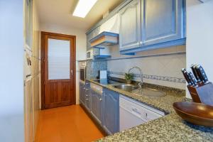 kuchnia z niebieskimi szafkami i zlewem w obiekcie LAS CALAS Nice apartment near the sea. w mieście Portopetro