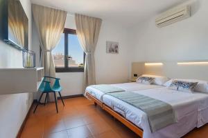 1 dormitorio con cama y ventana grande en LAS CALAS Nice apartment near the sea., en Portopetro
