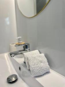 a bathroom sink with a towel and a mirror at Les Libournettes - Ambiance zen in Libourne
