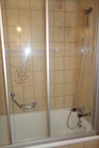 ducha con puerta de cristal junto a la bañera en Oree du Bois OB D0 CALM apartment 6 pers, en Veysonnaz