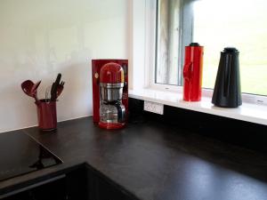 a kitchen counter with a red blender on a window sill at Luxurious cabin / 3 BR / Scenic village in Skálavík