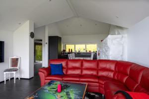 a red couch in a living room with a table at Luxurious cabin / 3 BR / Scenic village in Skálavík