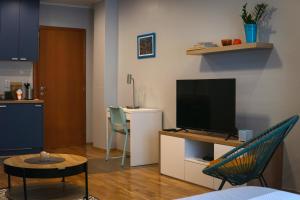 een woonkamer met een flatscreen-tv op een standaard bij Boulevard Studio Apartment in Novi Sad