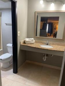 uma casa de banho com um lavatório, um WC e um espelho. em Guest Inn Lake City em Lake City