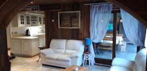 a living room with a white couch and a kitchen at Appartement Favre 73 in Moutiers