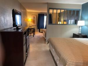 レイク・シティにあるGuest Inn Lake Cityのベッド1台、薄型テレビが備わるホテルルームです。