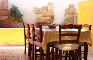 リド・マリーニにあるLido Marini Apartmentsのテーブル(椅子4脚付)とテーブル(黄色いテーブルクロス付)