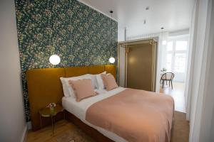 um quarto com uma cama grande e uma parede verde em Trovador Guest House em Guimarães