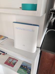 a white appliance sitting on a shelf in a refrigerator at Bilocale in residence vista lago con piscina in Polpenazze del Garda