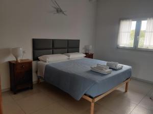 1 dormitorio con 1 cama con 2 toallas en Bilocale in residence vista lago con piscina en Polpenazze del Garda