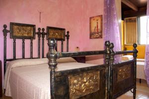 リド・マリーニにあるLido Marini Apartmentsのピンクの壁のベッドルーム1室(ベッド1台付)