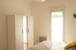 um quarto com um armário branco e uma cama em Villa Saint Fort - Résidence Services em Saint-Fort