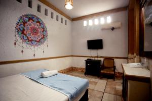 a room with a bed and a sink and a tv at Budarno Homestay in Yogyakarta