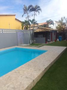 a swimming pool in front of a house at Casa em Village com piscina e perto da praia in Salvador