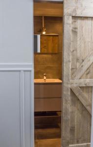 a bathroom with a sink and a wooden door at Koffie- en eethuis de Heerlijckheid in Nijmegen