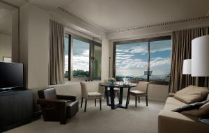 a living room with a table and chairs and a large window at NJV Athens Plaza in Athens