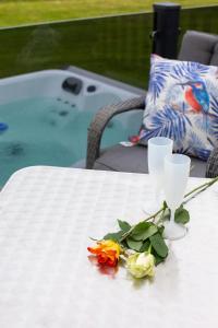 Biały stół z dwoma kieliszkami i kwiatami w obiekcie Stewarts Resort Lodge 35 w mieście St Andrews