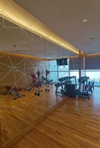 a gym with chairs and a large glass wall at Heaven Escape surrounded by stunning golf view High floor -Netflix-GYM-pool -perfect vacations in Dubai +24 photos
