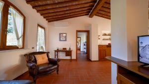 ein Wohnzimmer mit einem Stuhl und einem TV in der Unterkunft Il Cottage di Patrizia in Lucca