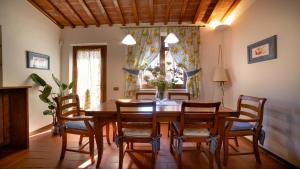 ein Esszimmer mit einem Holztisch und Stühlen in der Unterkunft Il Cottage di Patrizia in Lucca