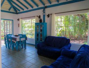 a living room with a blue couch and a table at Casa com saida privativa para a Praia do Felix SP in Ubatuba