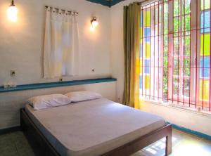 a bedroom with a bed and two windows at Casa com saida privativa para a Praia do Felix SP in Ubatuba