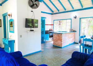 a living room with a couch and a tv at Casa com saida privativa para a Praia do Felix SP in Ubatuba
