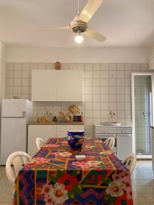 een keuken met een tafel met een kleurrijk tafelkleed erop bij Like Home Calamazzo di Sciacca in Scopello