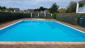 een groot blauw zwembad in een tuin bij La Baule, studio cosy. Quartier Jumping/Atlantia in La Baule