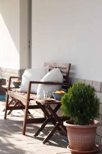 a wooden bench sitting on a patio with a table at VITEDIMARE APARTMENT SOLE - SUN in Muggia