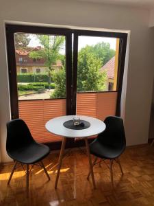 a table and two chairs in front of a window at Noclegi U Bram Klasztoru in Stary Sącz