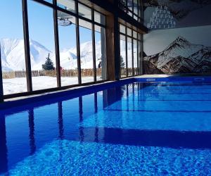 una piscina con vistas a las montañas cubiertas de nieve en Atrium New Gudauri en Gudauri