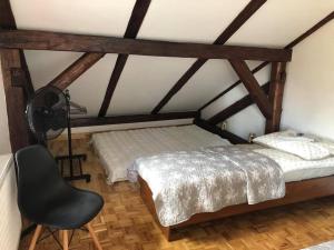 1 dormitorio con 1 cama y 1 silla en una habitación en Noclegi U Bram Klasztoru, en Stary Sącz