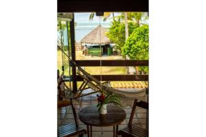 un balcone con tavolo e sedie e vista sull'oceano di Casa de frente para a praia - Arraial d' Ajuda a Arraial d'Ajuda