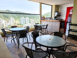 un restaurant avec des tables et des chaises et une grande fenêtre dans l'établissement Apartasuites VITA 945 RODADERO - By Bedviajes, à Santa Marta