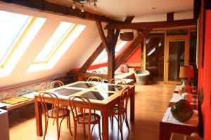 een keuken met een tafel en stoelen in een kamer bij Gite ferme XVIII 4 chambres /8 personnes Chimay in Momignies