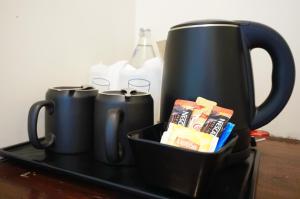a tray with two black coffee mugs on a table at Montree Phuket Hotel in Phuket Town