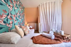 sypialnia z łóżkiem i ścianą w kwiaty w obiekcie La cabanette du sunset 6 w mieście Guidel