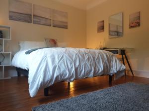 een slaapkamer met een bed met een wit dekbed bij Little Robin Gate - Free Parking - Central - 10 min Walk to Train Station in Bournemouth