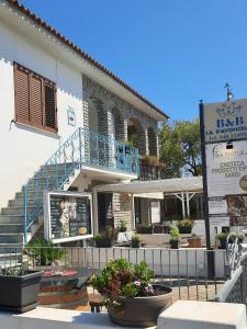 聖特奧多羅的住宿－帕文切拉住宿加早餐旅館，一座带蓝色阳台和一些植物的建筑