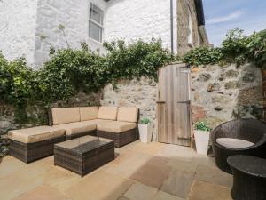 a patio with a couch and tables and a building at Meledor in Marazion
