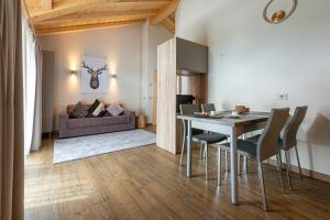 a dining room with a table and chairs and a couch at Fontana Chalet St Antoni in Livigno