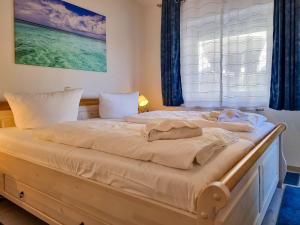 ein großes Bett in einem Zimmer mit Fenster in der Unterkunft Ferienwohnung Sonnenblick in Sassnitz