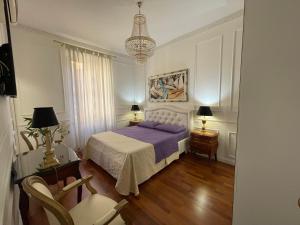 a bedroom with a bed and two chairs and a chandelier at King Plaza in Rome